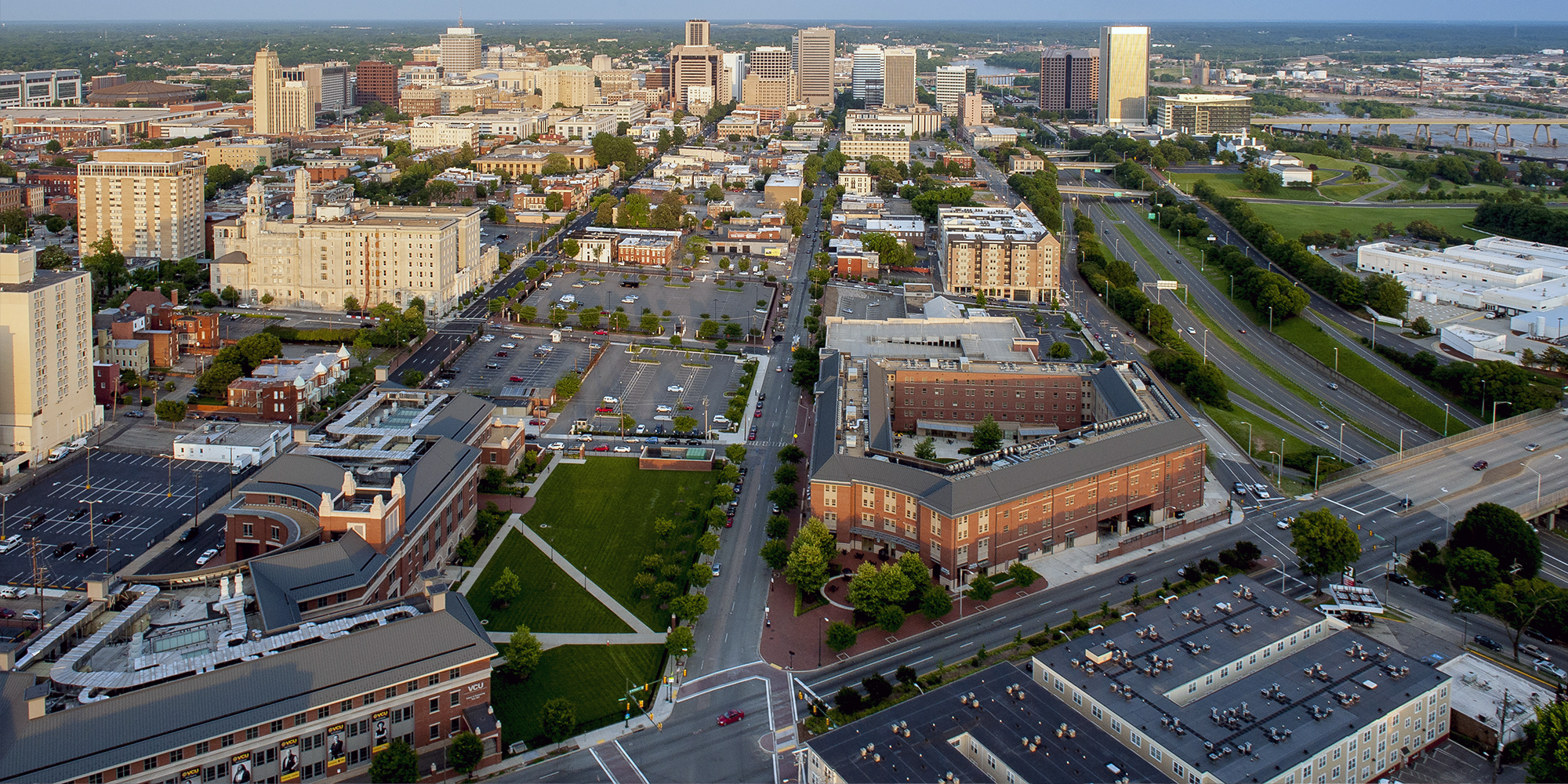 Partial aerial view of the VCU Monroe Park Campus, showing in foreground, School of Engineering East Hall, School of Business Snead Hall, and Brand Center Hughes Hall, Downtown Richmond, VA in the background 